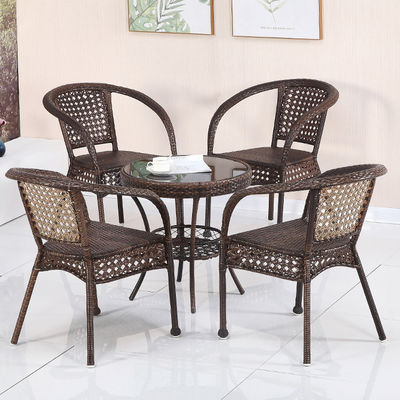 Buiten tuinbalkon stapelbare fauteuil en wicker eettafel voor vrije tijd