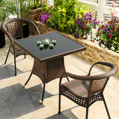 Buiten tuinbalkon stapelbare fauteuil en wicker eettafel voor vrije tijd